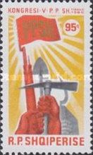 Fists holding rifle, spade, axe, sickle and book