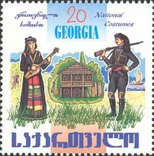 Woman, House and Man Holding Rifle