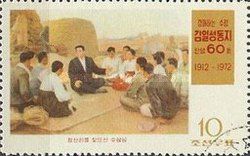 Kim Il Sung sitting with villagers