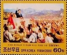 Kim Il Sung at the lectern greets the crowd