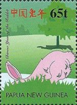 Pink rabbit hiding behind grass knoll