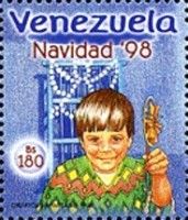 Boy standing in front of windows with pinwheel.