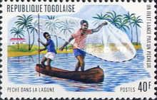 Fisherman casting net from canoe