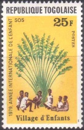 Children sitting under African fan palm